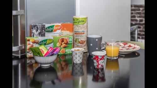 a table with a box of cereal and a glass of orange juice at Gite "le millésime" in Épernay