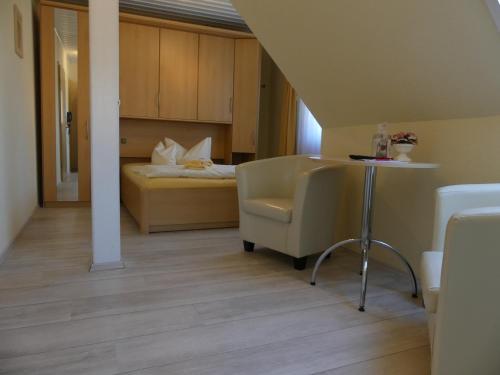 a room with a bed and a table and a chair at Ferienhotel Wolfsmühle in Rodishain