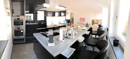 una cocina con una mesa grande con sillas negras en Apartment Central Würzburg en Würzburg
