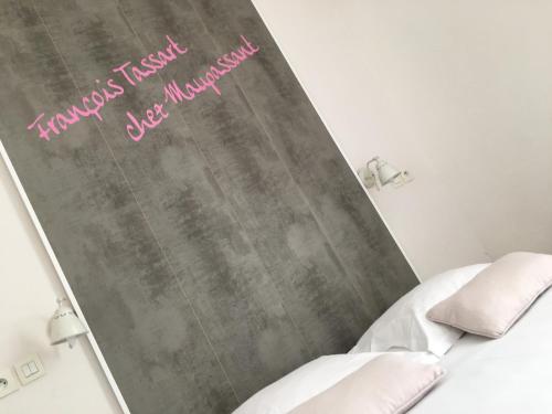 a bedroom with a chalkboard with a bed and two pillows at Hotel Chalet De L'isere in Cannes