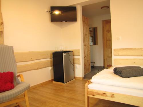 a living room with a refrigerator and a chair at Przy Szlaku Zakopane centrum pokoje & apartamenty in Zakopane