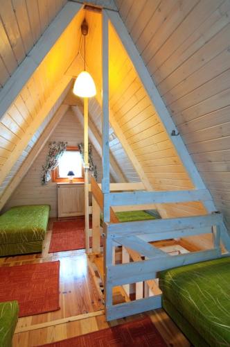 an attic room with a ladder in a room at Bajeczne domki in Ustka