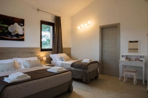 a hotel room with two beds and a desk at BorgoPratole CountryHouse in Cingoli