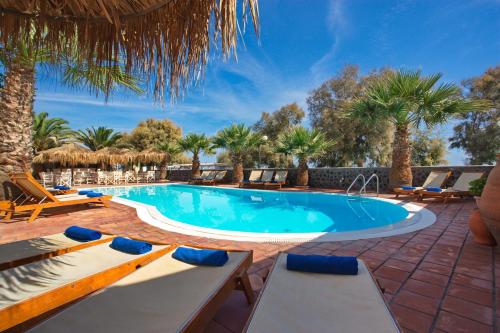 uma piscina com espreguiçadeiras e um resort em The Boathouse Hotel em Kamari