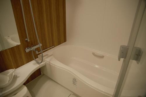 a bathroom with a bath tub and a toilet at Mountain Home Lodge in Deer Park in Nara