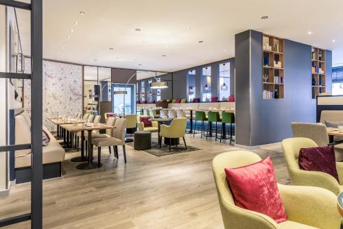 a restaurant with tables and chairs and a bar at Mercure Hotel Hannover Mitte in Hannover