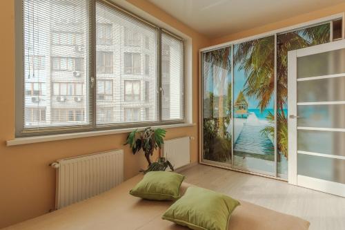 a bedroom with a bed and a large window at RainBow Arkadia Apartment in Odesa
