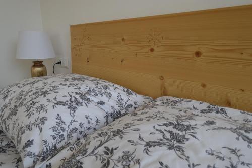 a bed with a blue and white blanket and a lamp at Willa Zaolzie in Istebna