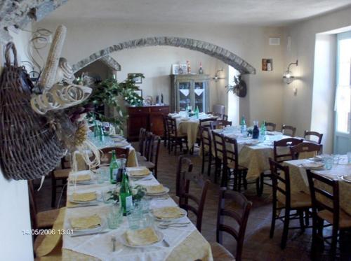 un comedor con mesas y sillas en un restaurante en Agriturismo Il Vecchio Casale, en Vatolla