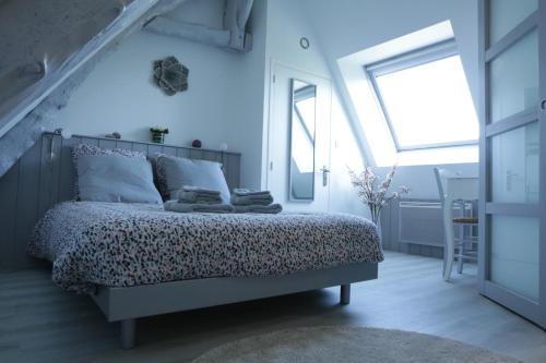 une chambre avec un lit et une grande fenêtre dans l'établissement Le Clos d'Esquay, Côté Seulles, à Esquay-sur-Seulles