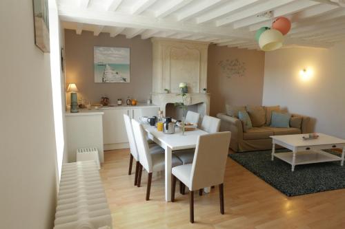 une cuisine et un salon avec une table et des chaises dans l'établissement Le Clos d'Esquay, Côté Seulles, à Esquay-sur-Seulles