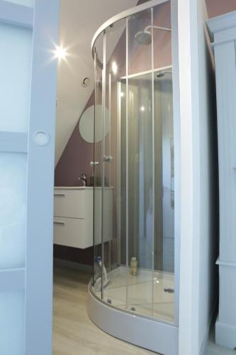 une douche en verre dans une salle de bain avec un lavabo dans l'établissement Le Clos d'Esquay, Côté Seulles, à Esquay-sur-Seulles