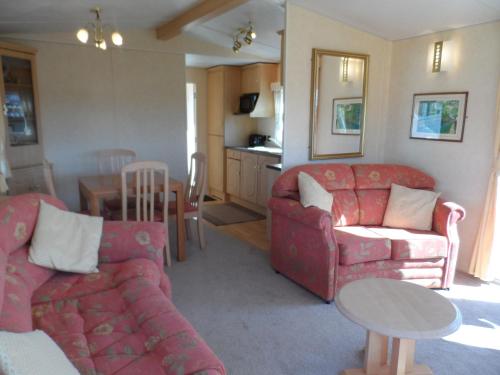 a living room with two couches and a table at Luxury Mobile Home near Perranporth situated on a quiet farm in Truro
