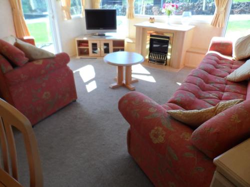 a living room with a couch and a table at Luxury Mobile Home near Perranporth situated on a quiet farm in Truro