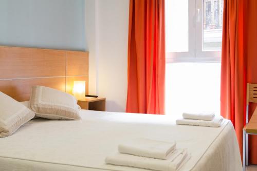 a bedroom with a bed with towels on it at Ekia Pentsioa in Zarautz