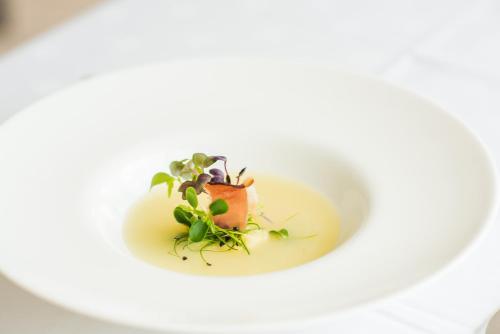 a white plate with a dish on top of it at Sporthotel St. Michael in Malles Venosta