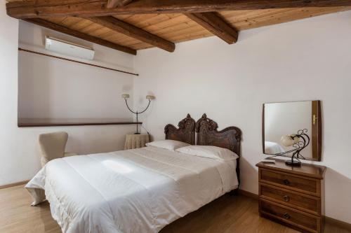 sypialnia z łóżkiem z lustrem i komodą w obiekcie Alcalà Living Apartments w Katanii