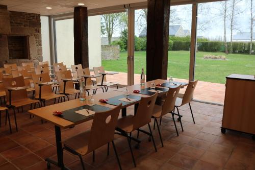 une grande salle à manger avec des tables, des chaises et des fenêtres dans l'établissement Le Saint Aubert, au Mont-Saint-Michel