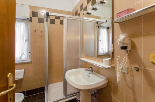 uma pequena casa de banho com um lavatório e um chuveiro em Appartamento Continental - 8 posti letto em San Vito di Cadore