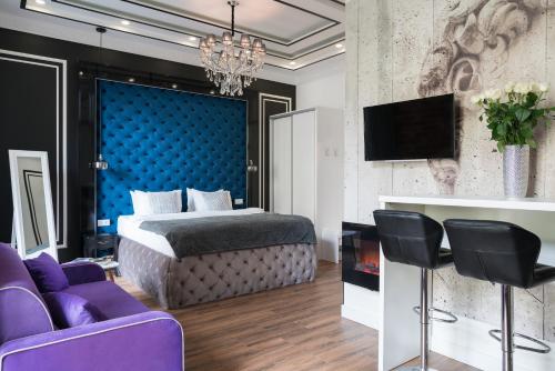 a bedroom with a bed and a tv and purple furniture at Theatre Boutique Apart-Hotel in Kyiv