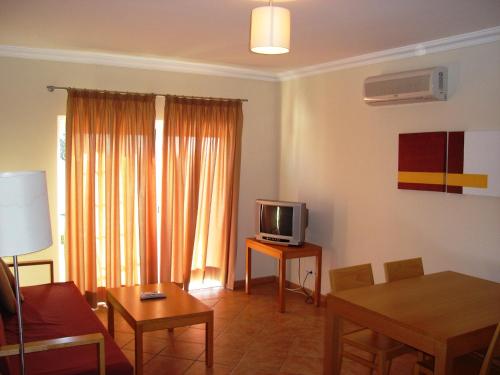 a living room with a couch and a tv and a table at Alagoa Azul II in Altura