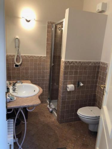 La salle de bains est pourvue d'un lavabo, de toilettes et d'une douche. dans l'établissement Locanda Agli Angeli, à Gardone Riviera
