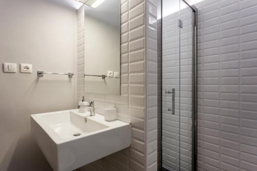 a white bathroom with a sink and a shower at Alcalà Living B&B in Catania