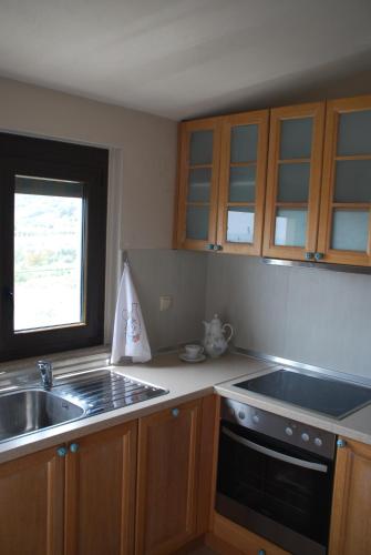 a kitchen with a sink and a stove at Olive Tree Cottage in Nea Peramos