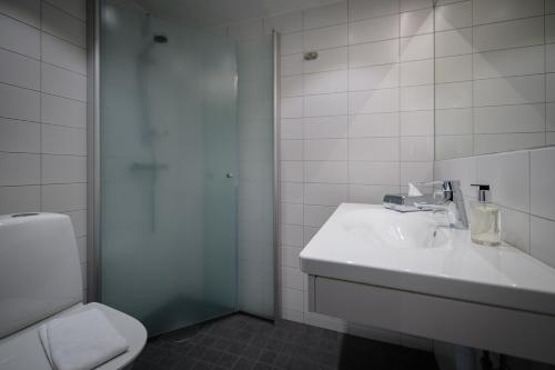 a white bathroom with a sink and a toilet at Hotell Alfred Nobel in Karlskoga