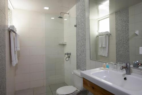 a bathroom with a sink and a toilet and a mirror at Hotel whala!boca chica - All Inclusive in Boca Chica