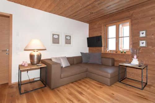 a living room with a couch and two tables at Alpin Chalet Schröcken in Schröcken