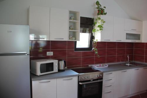 a kitchen with white cabinets and a microwave at Apartments Dijana in Kotor