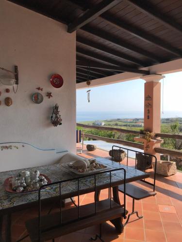 a room with a table and a balcony with a view at Case del Tramonto in Ustica