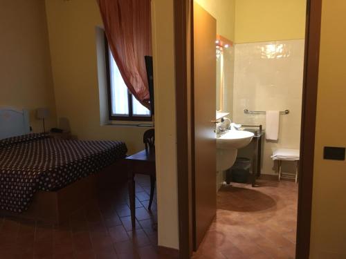 a bathroom with a bed and a sink and a toilet at Locanda dell'Oca Bianca in Como