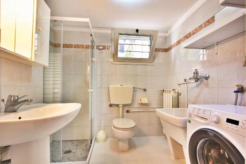 bagno con lavabo, servizi igienici e lavatrice. di Villa Russo a Lignano Sabbiadoro
