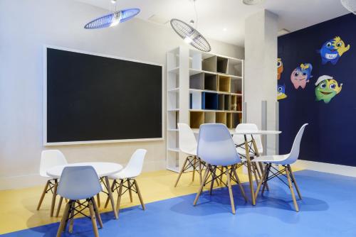 a classroom with white chairs and a blackboard at Ilunion Hacienda de Mijas in Mijas