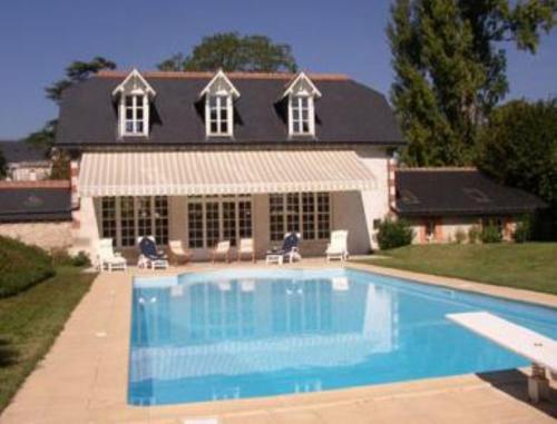 une maison avec une piscine devant une maison dans l'établissement Appartement du Château du Grand Bouchet, à Ballan-Miré