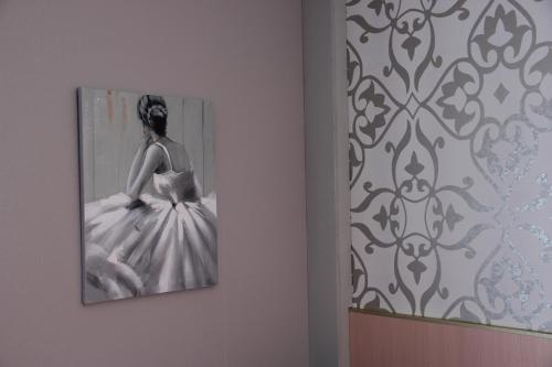 a picture of a woman in a dress on a wall at Hôtel Restaurant le Panorama in Évian-les-Bains