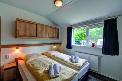 a bedroom with two beds with towels on them at Ferienpark Wulfenerhals in Wulfen auf Fehmarn