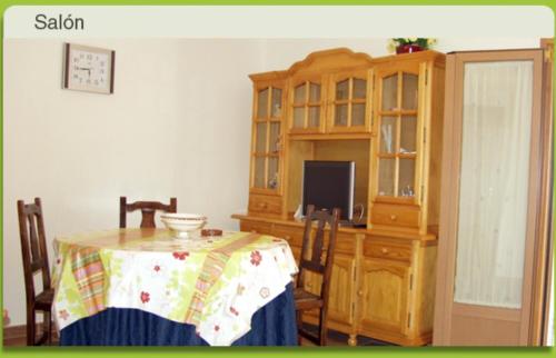 ein Esszimmer mit einem Tisch und einem Schrank in der Unterkunft Apartamento Rural Los Adobes I in Pedro Bernardo