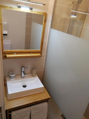une salle de bain avec un lavabo et un miroir dans l'établissement Appt. Bella Vita - Andernos les Bains, au cœur du Bassin d'Arcachon, à Andernos-les-Bains