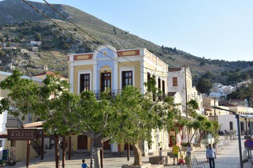 a street in a town with a mountain in the background at Myrtia in Symi