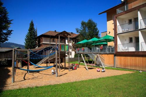einen Spielplatz in einem Hof neben einem Gebäude in der Unterkunft Hotel Gasthof Adler in Lingenau