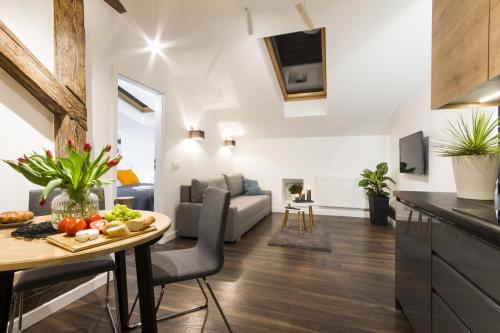 een keuken en een woonkamer met een tafel met groenten bij Apartments Floriańska 24 in Krakau