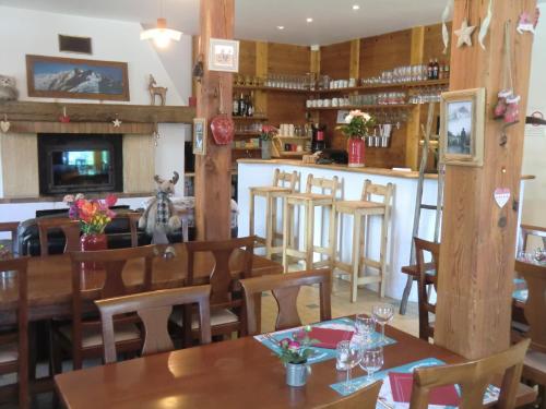 un restaurant avec des tables et des chaises en bois ainsi qu'un bar dans l'établissement Auberge du Pont de l'Alp, au Monêtier-les-Bains