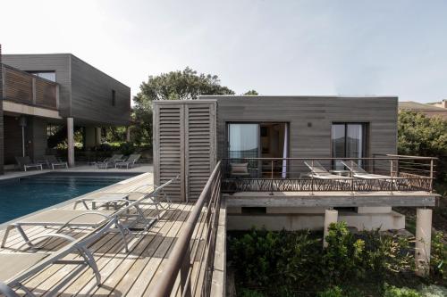 uma casa com um deque e uma piscina em Le Tomino em Macinaggio