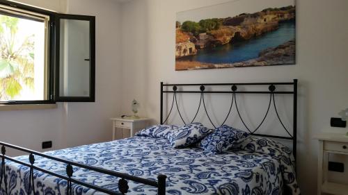 a bed with a blue and white comforter in a bedroom at A casa di Lina in San Foca