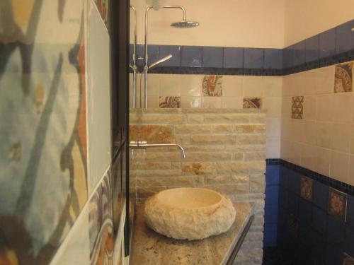 a bathroom with a stone toilet in a shower at A casa di Lina in San Foca