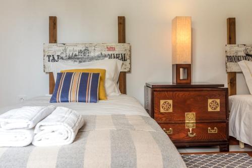 a bedroom with a bed and a dresser with towels on it at Villa 39 in Armação de Pêra