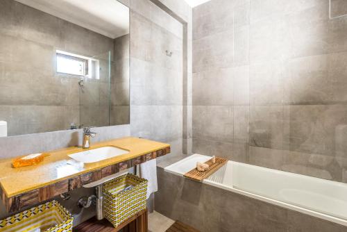 uma casa de banho com um lavatório e uma banheira em Villa 39 em Armação de Pêra